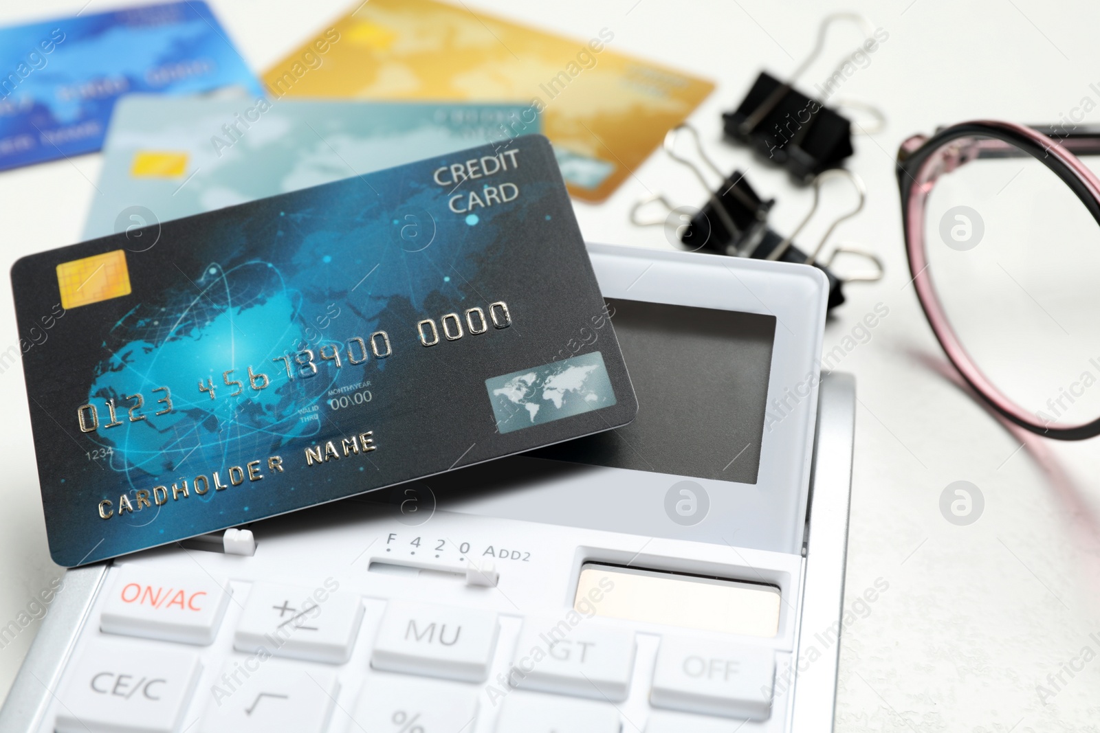 Photo of Credit card and calculator on white table, closeup