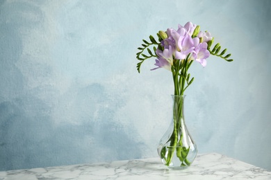 Photo of Bouquet of fresh freesia flowers in vase on table. Space for text