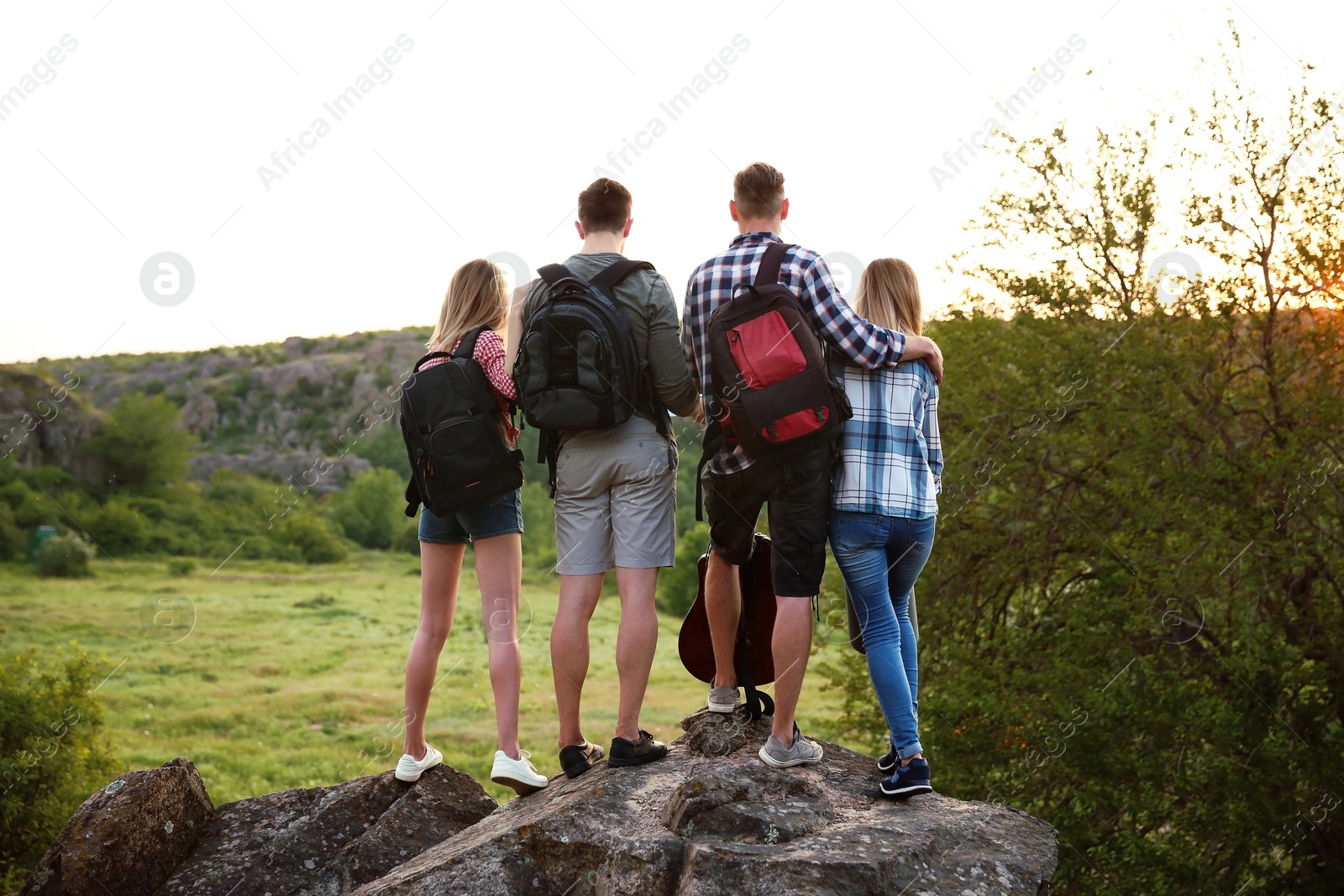 Photo of Group of young people with backpacks in wilderness. Camping season