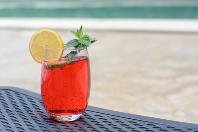 Glass of delicious cocktail on table outdoors, space for text. Refreshing drink