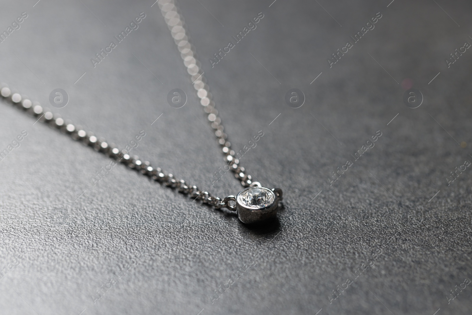 Photo of Beautiful necklace with gemstone on light gray background. Luxury jewelry