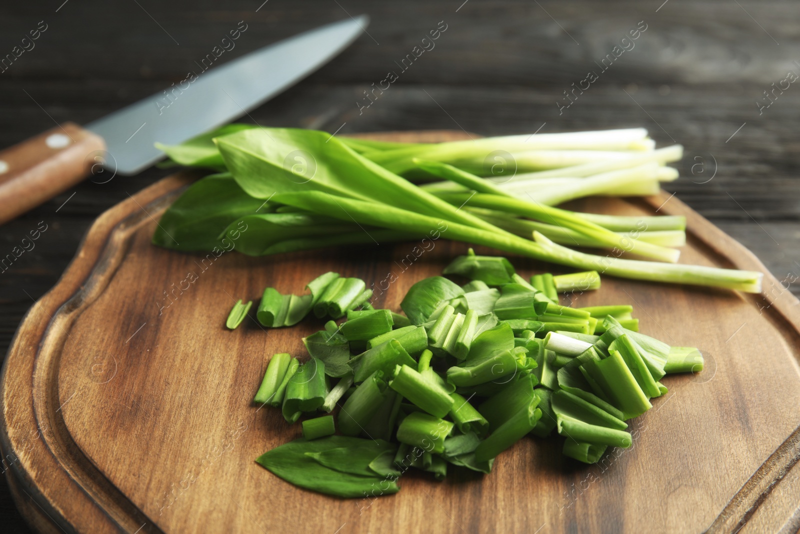 Photo of Board with wild garlic or ramson on table, closeup