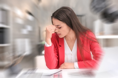 Photo of Young woman suffering from headache in office