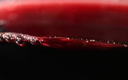 Delicious red wine in glass as background, closeup