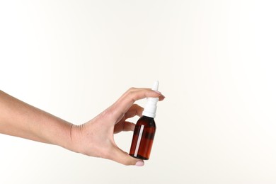 Photo of Woman holding nasal spray on white background, closeup