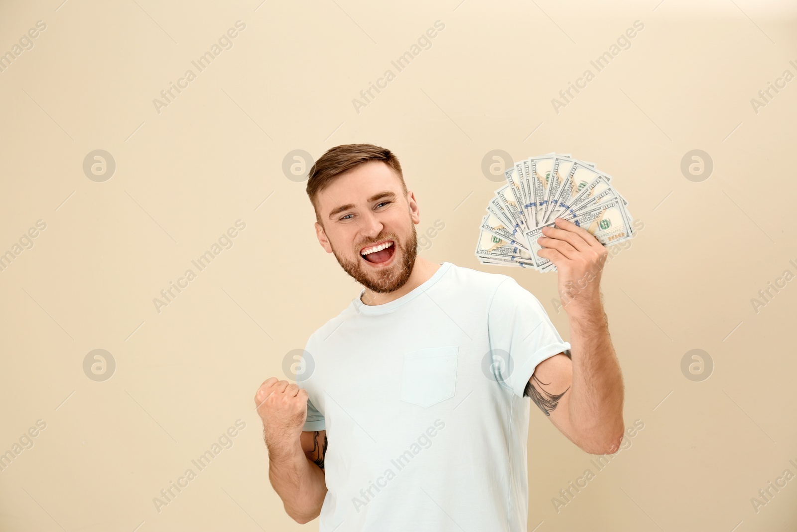 Photo of Portrait of emotional young man with money on color background