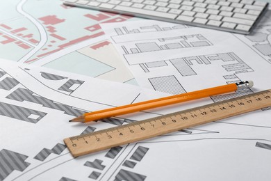 Pencil and ruler on cadastral maps of territory with buildings