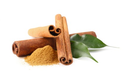 Dry aromatic cinnamon sticks, powder and green leaves isolated on white