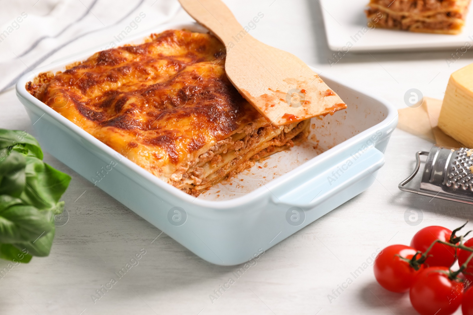 Photo of Delicious lasagna in baking dish on white table