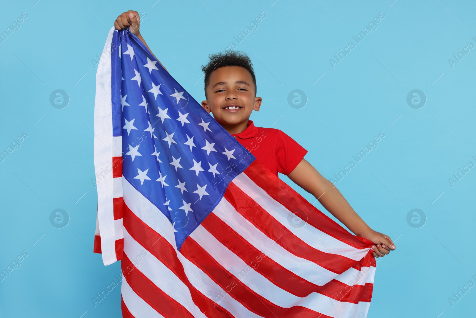 Photo of 4th of July - Independence Day of USA. Happy boy with American flag on light blue background