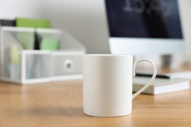 Photo of Blank ceramic mug on wooden table. Mockup for design
