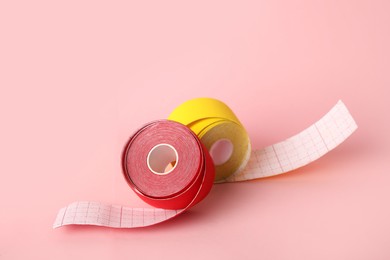 Photo of Bright kinesio tape in rolls on pink background