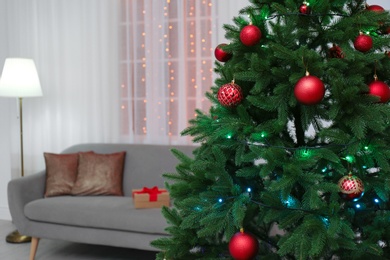 Photo of Stylish Christmas interior with fir tree and comfortable sofa