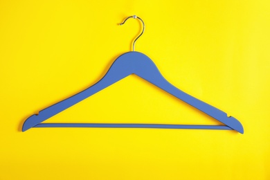 Photo of Empty clothes hanger on color background. Wardrobe accessory