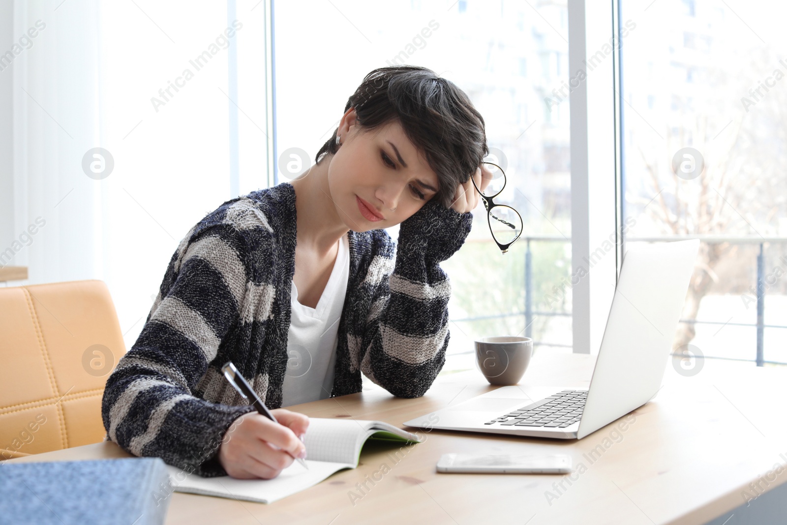 Photo of Young woman working at desk. Home office