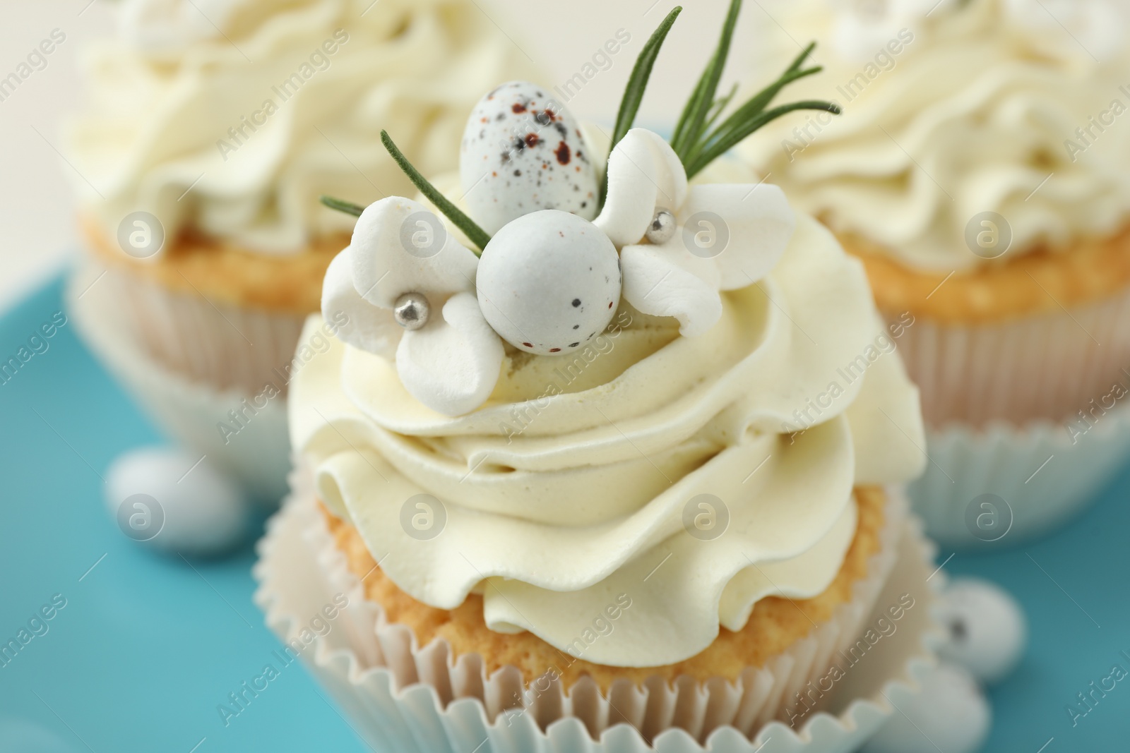 Photo of Tasty Easter cupcakes with vanilla cream on table, closeup