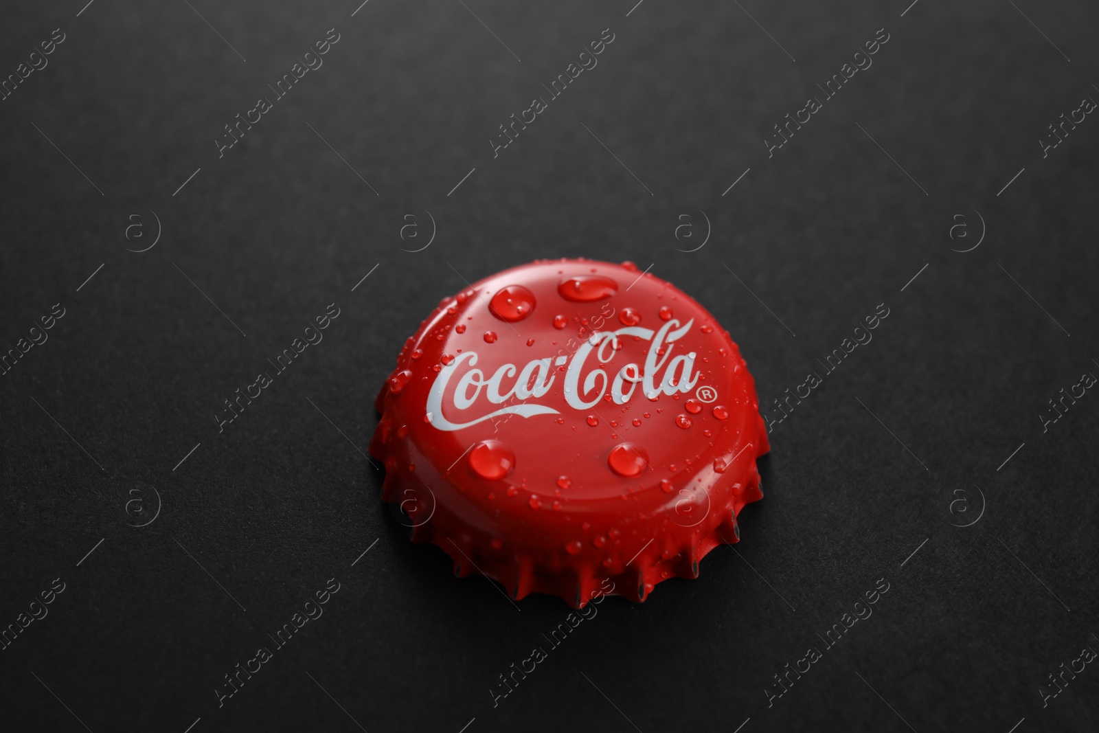 Photo of MYKOLAIV, UKRAINE - NOVEMBER 15, 2018: Coca Cola lid on black background