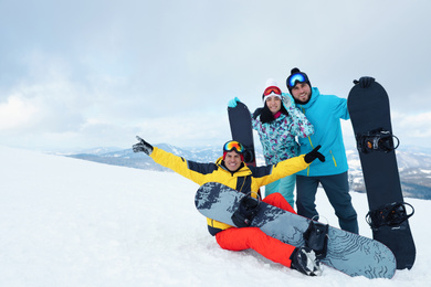 Photo of Group of friends with equipment in snowy mountains. Winter vacation