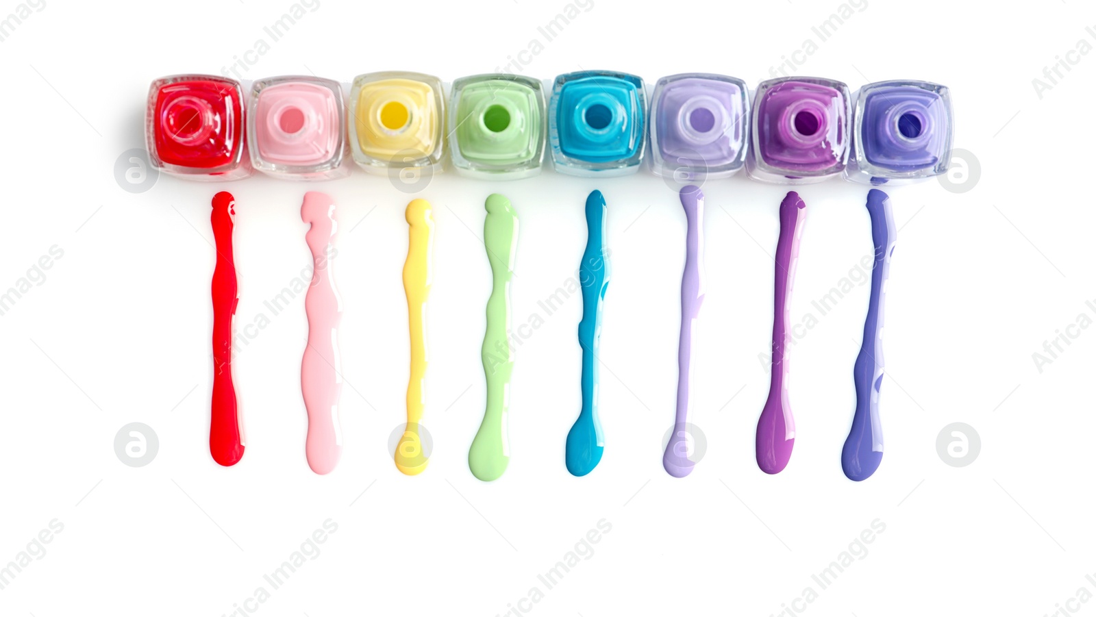 Photo of Spilled colorful nail polishes and bottles on white background, top view