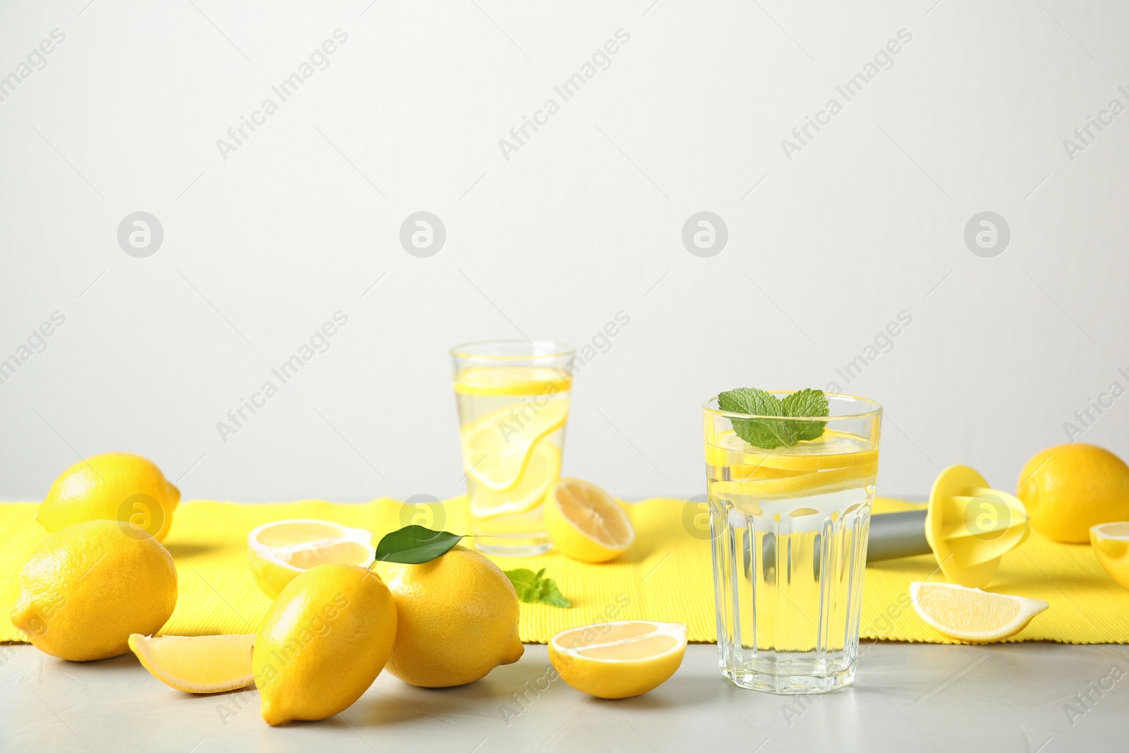 Photo of Glass with lemon water and fresh fruits on table