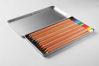 Photo of Box with many colorful pastel pencils on light grey background. Drawing supplies