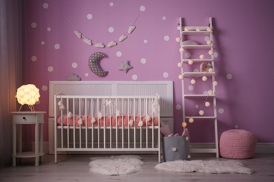 Baby room interior with crib near color wall