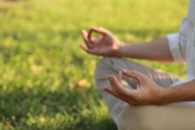 Photo of Man meditating outdoors on sunny day, closeup. Space for text