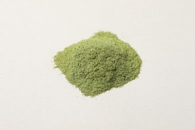 Pile of wheat grass powder on light table, closeup