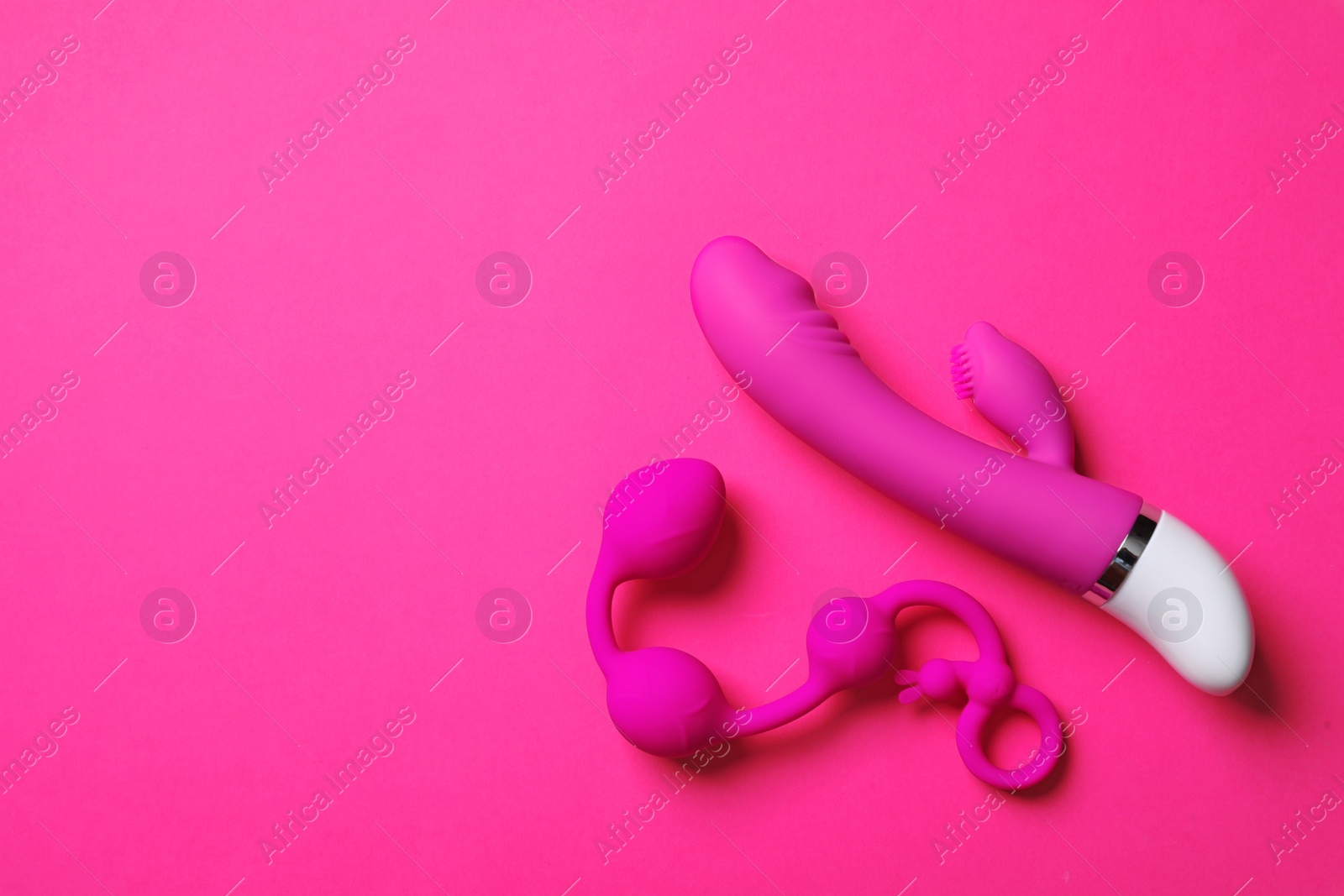 Photo of Anal balls and dildo on pink background, flat lay with space for text. Sex toy