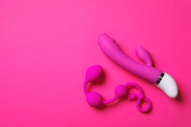 Photo of Anal balls and dildo on pink background, flat lay with space for text. Sex toy