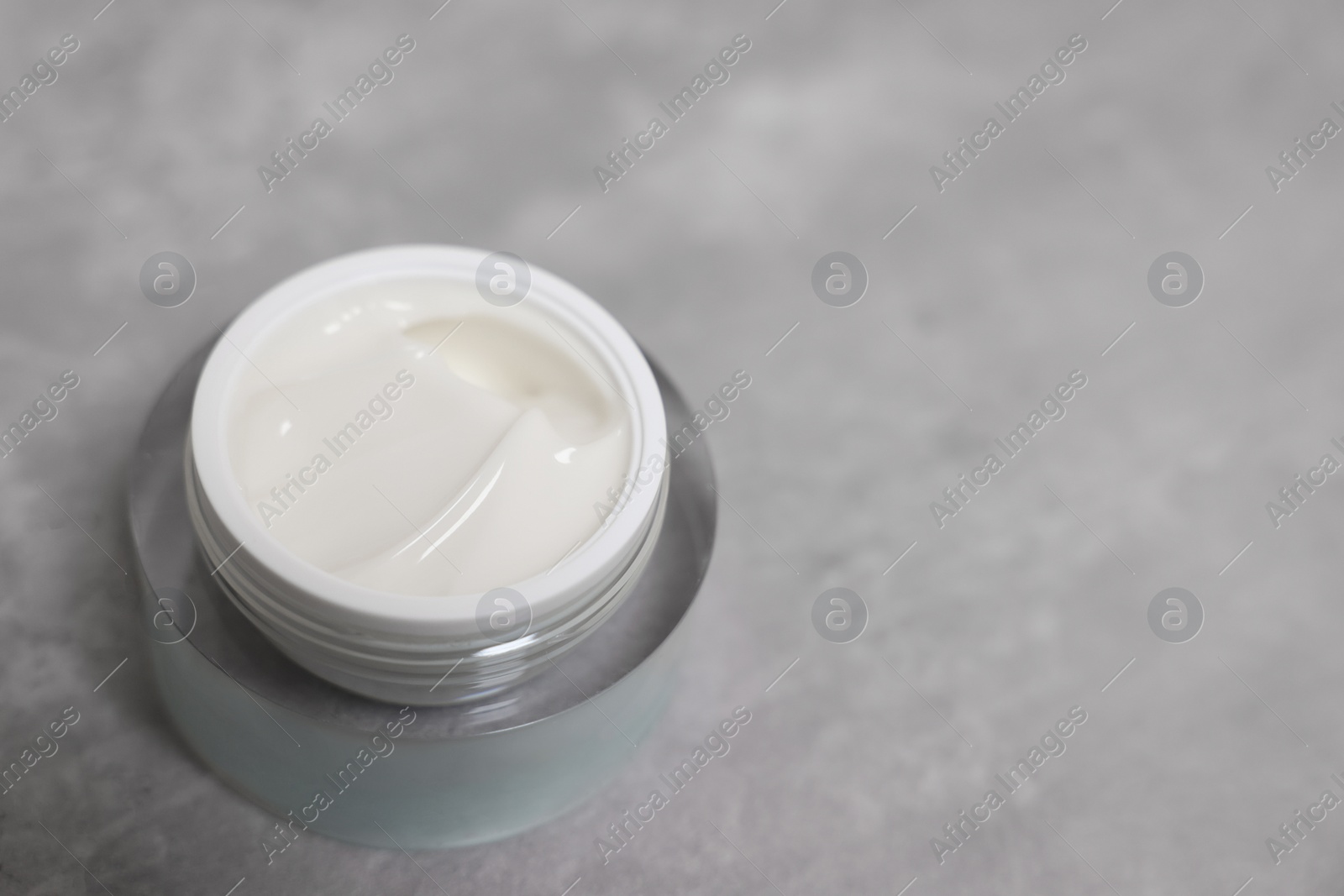 Photo of Body cream on grey table, closeup. Space for text