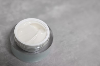 Photo of Body cream on grey table, closeup. Space for text