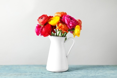 Photo of Vase with beautiful spring ranunculus flowers on table