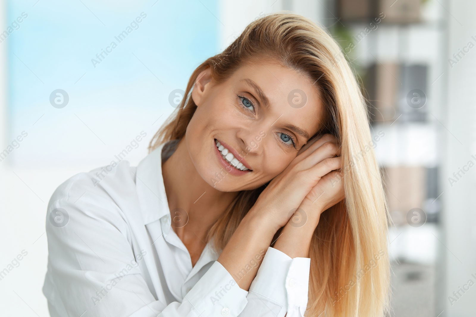 Photo of Portrait of smiling woman in formal clothes. Charming blonde lady posing indoors