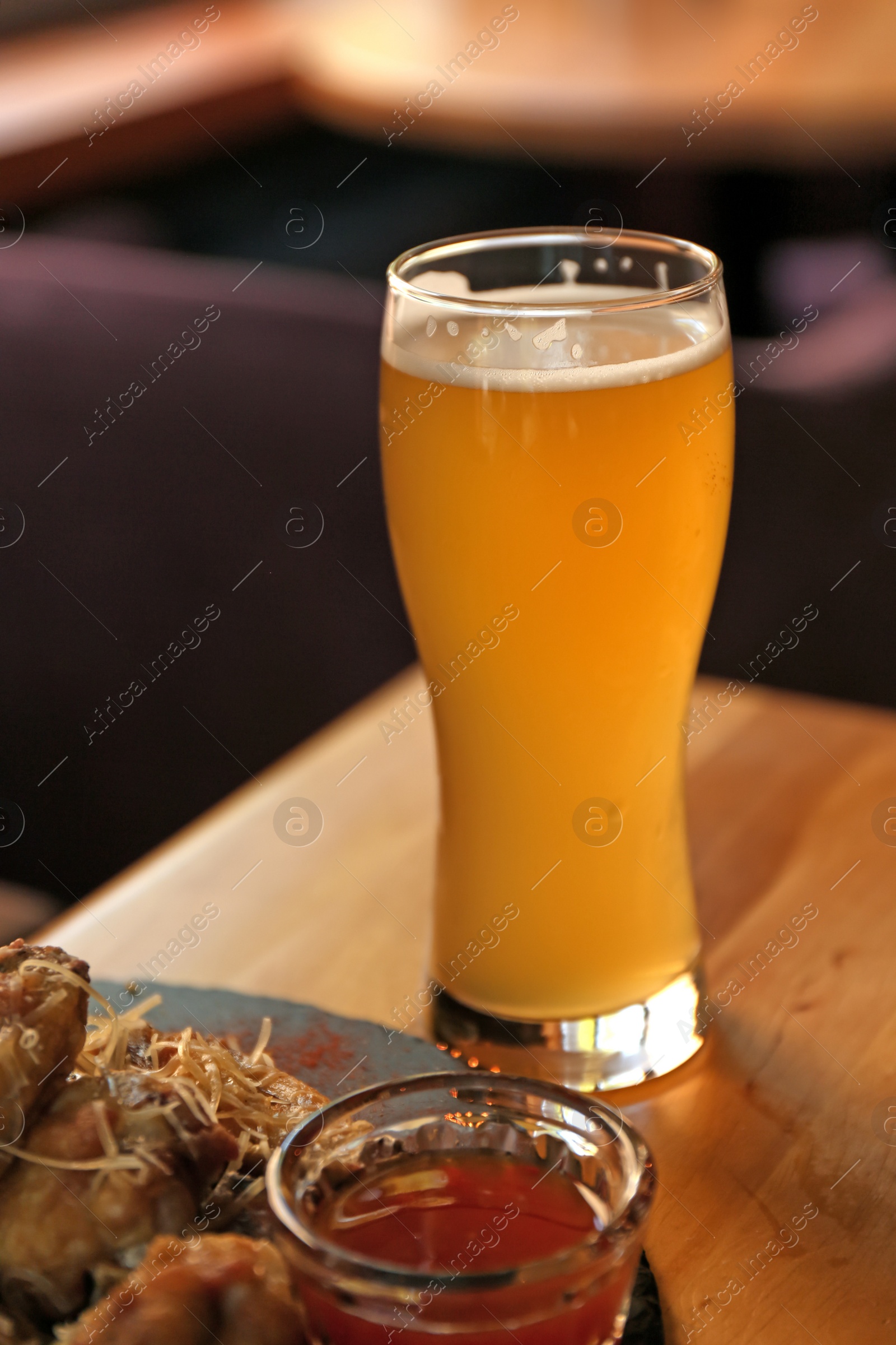 Photo of Delicious hot BBQ wings and beer served on table