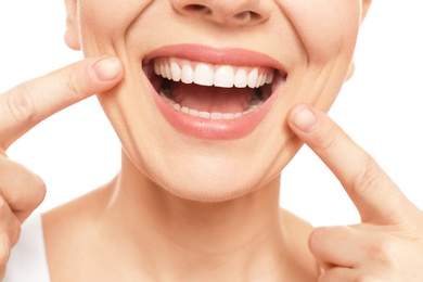 Young woman with beautiful smile on white background, closeup. Teeth whitening