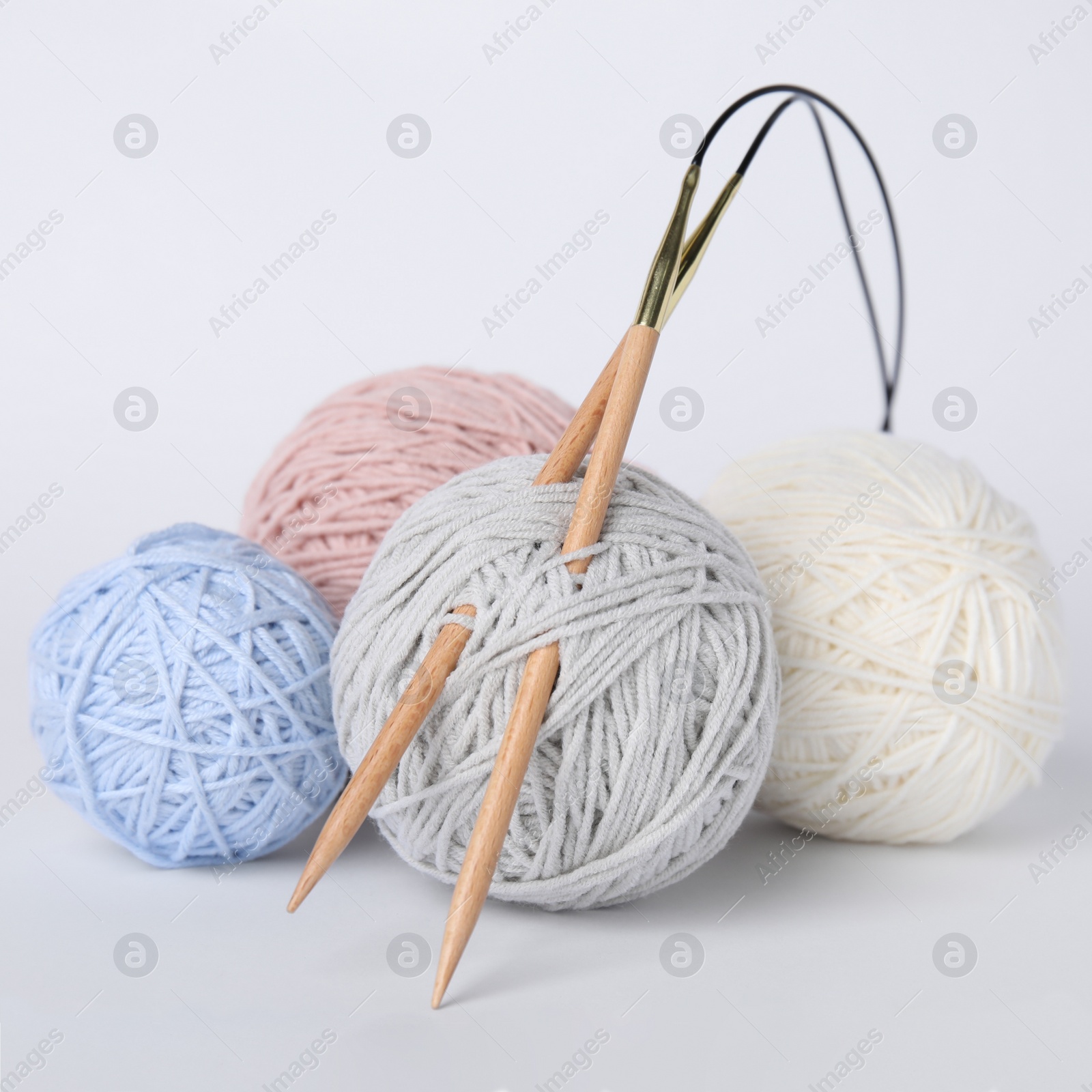 Photo of Soft woolen yarns and knitting needles on white background