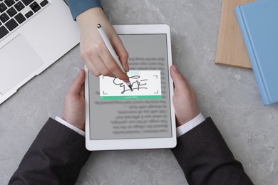 Image of Electronic signature. Woman using stylus and tablet at table, top view