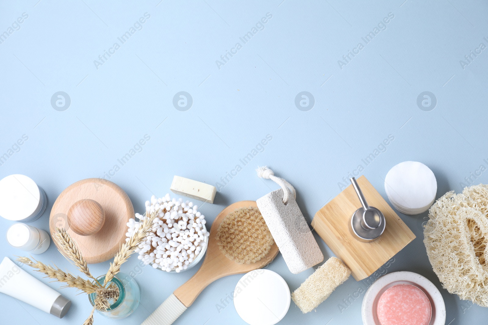 Photo of Bath accessories. Flat lay composition with personal care products on light blue background, space for text