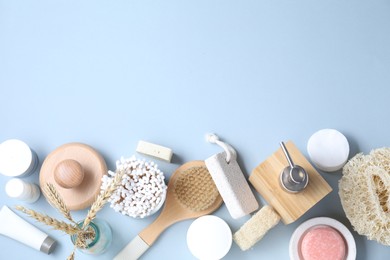 Bath accessories. Flat lay composition with personal care products on light blue background, space for text