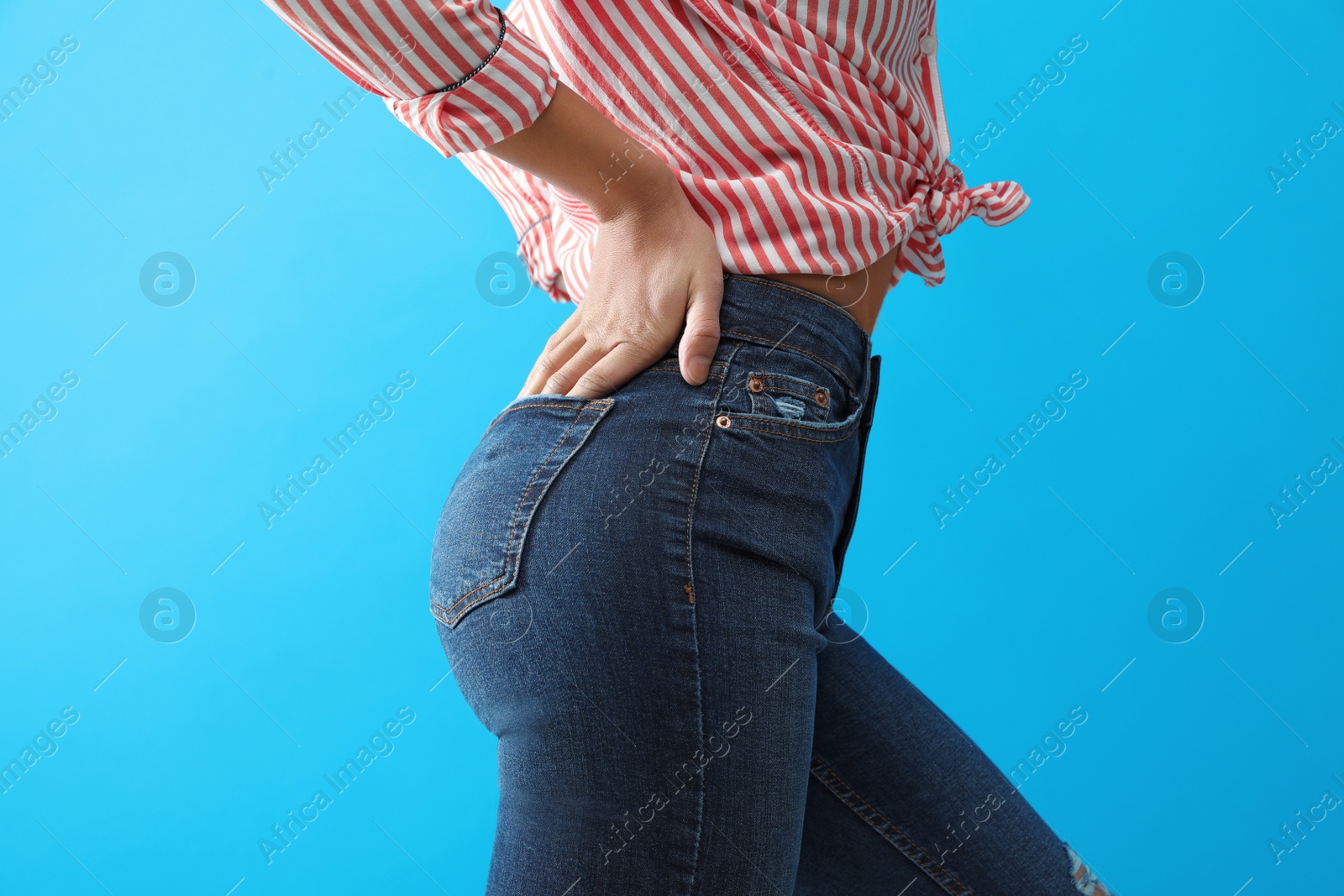 Photo of Woman wearing jeans on blue background, closeup