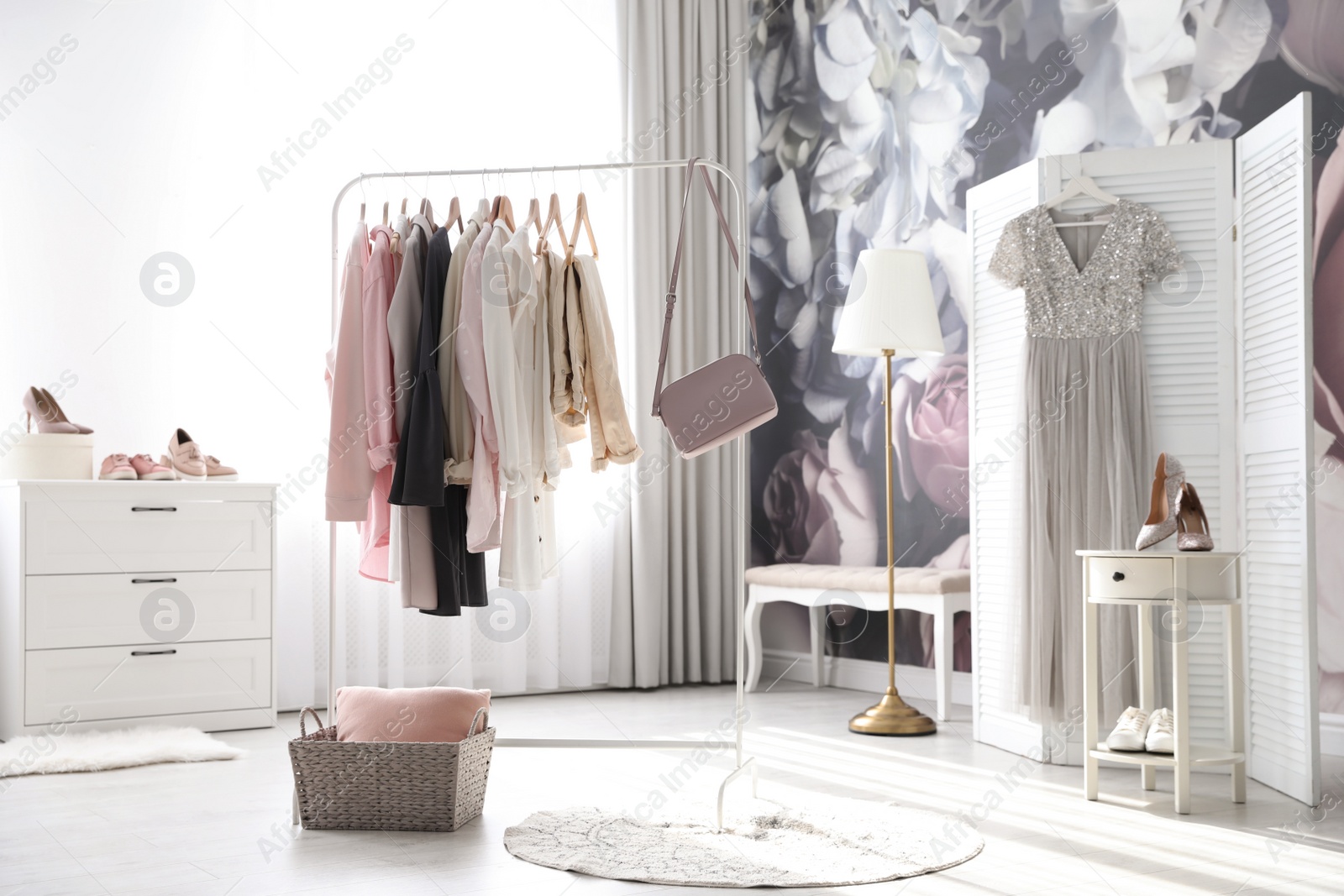 Photo of Rack with stylish women's clothes and handbag indoors. Interior design