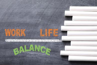 Image of Work-life balance concept. Pieces of chalk on blackboard, top view