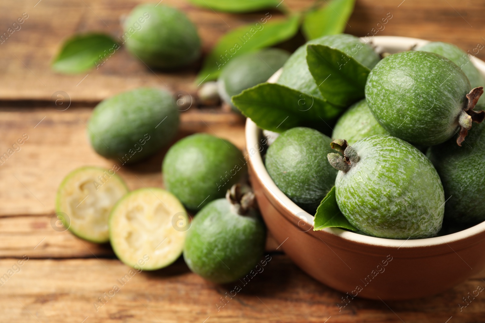 Photo of Fresh green feijoa fruits on wooden table, closeup. Space for text