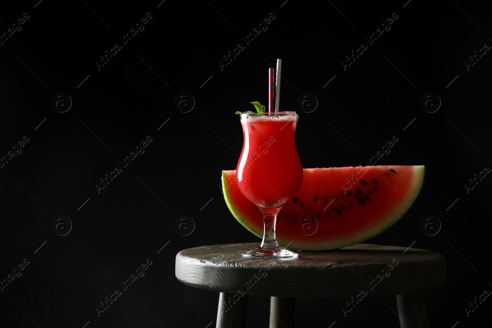 Photo of Tasty watermelon drink and fresh fruit on table against black background, space for text
