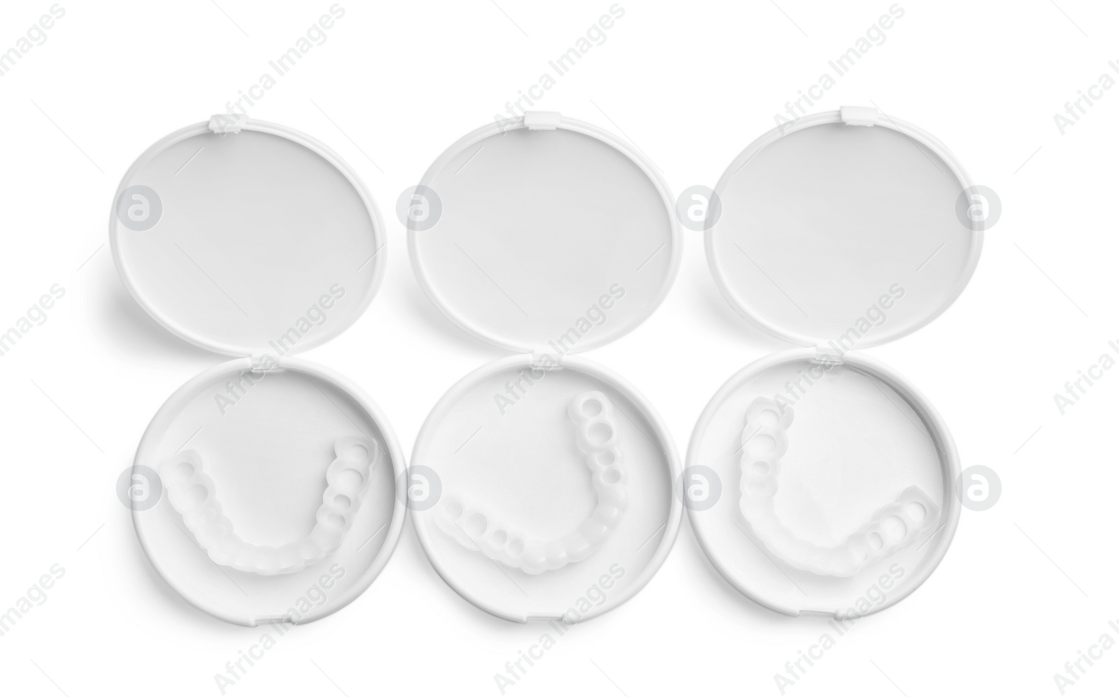 Photo of Dental mouth guards in containers on white background, top view. Bite correction