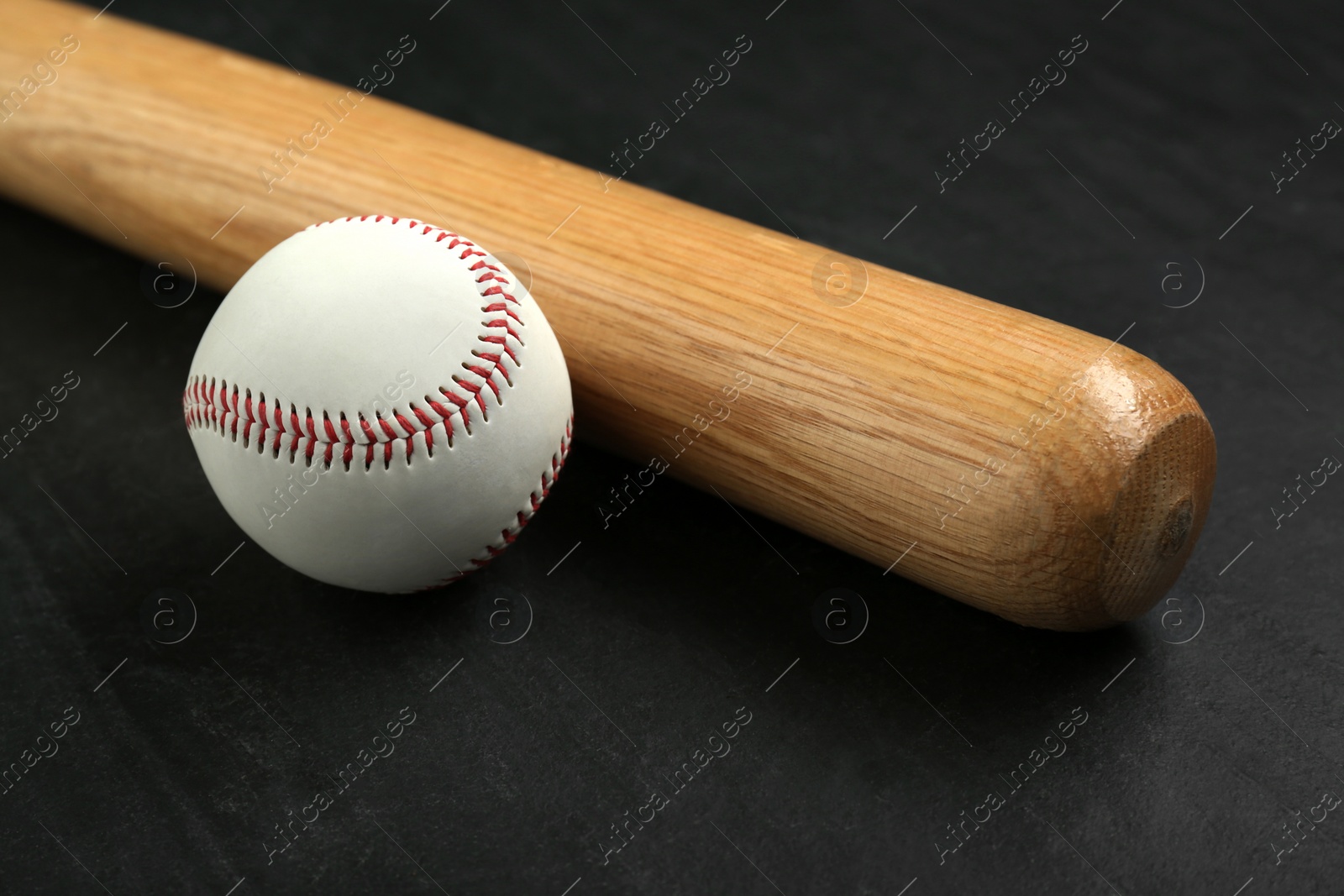 Photo of Baseball bat and ball on black background. Sports equipment