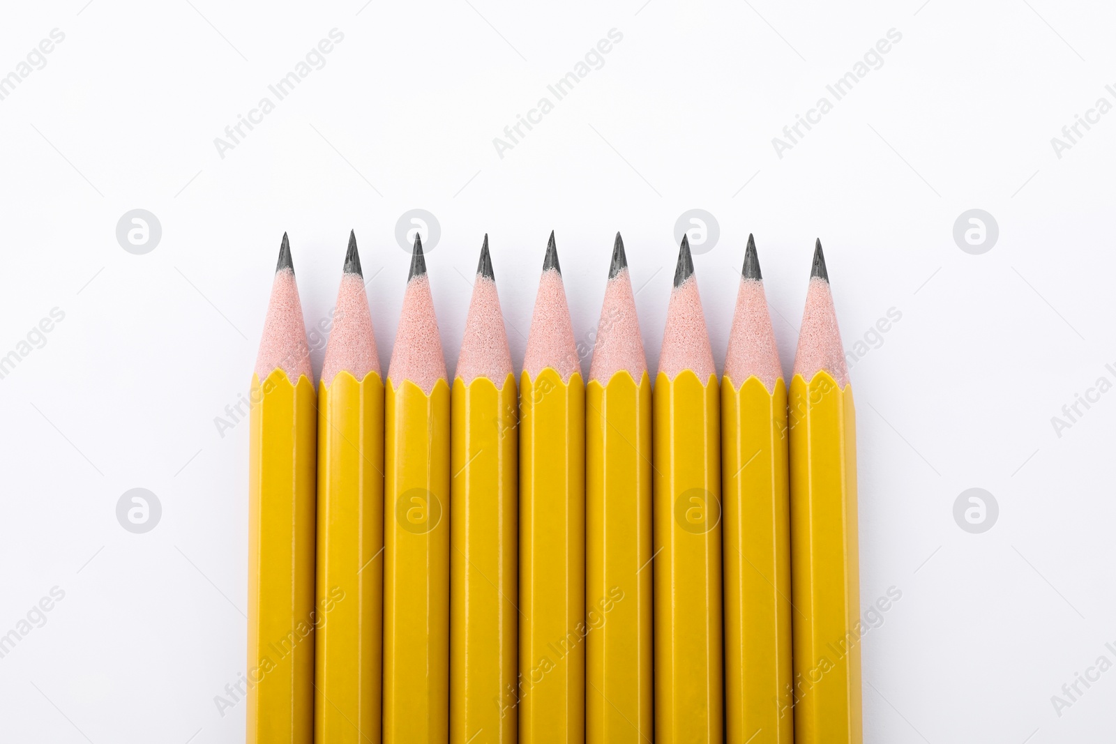 Photo of Many sharp graphite pencils on white background, top view