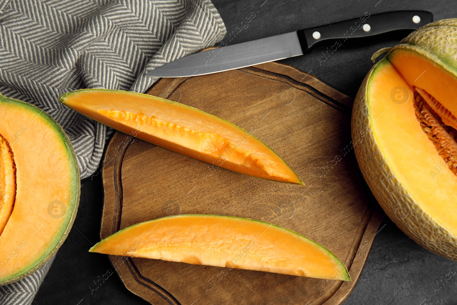 Photo of Tasty fresh melons on black table, flat lay