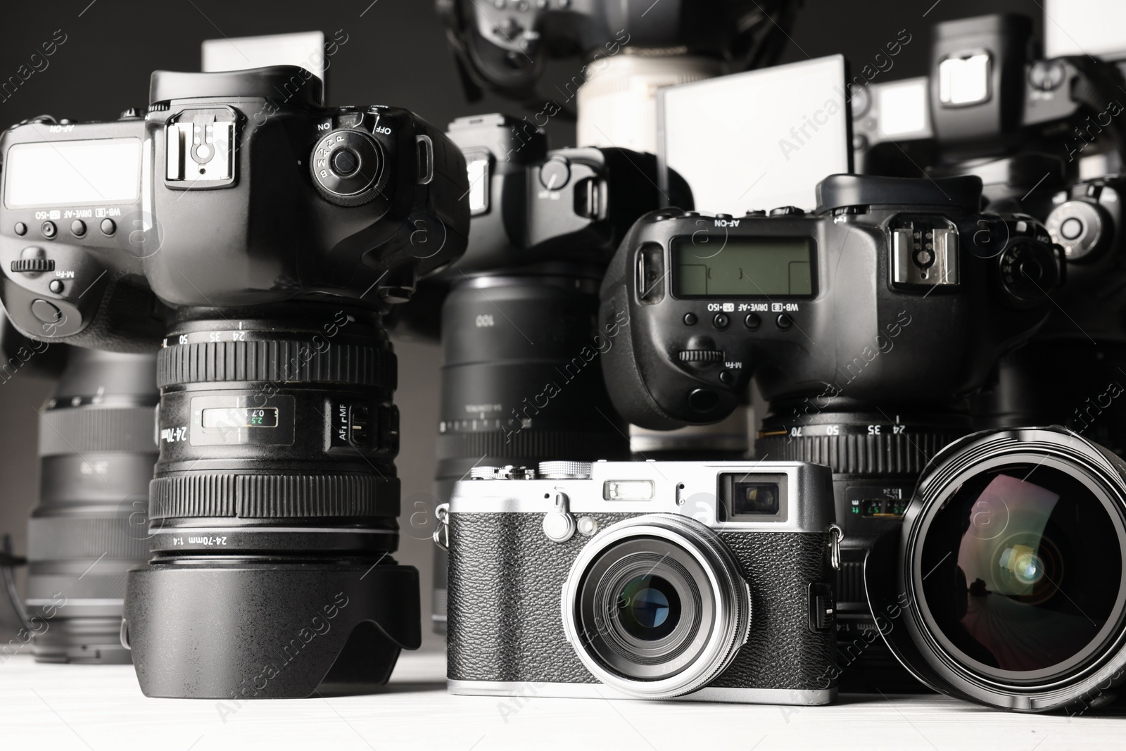 Photo of Modern cameras on white table, closeup. Professional photography equipment
